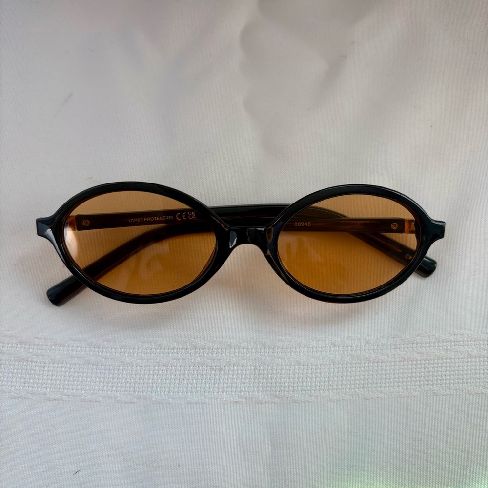 Oval glasses black frames and light brown lenses